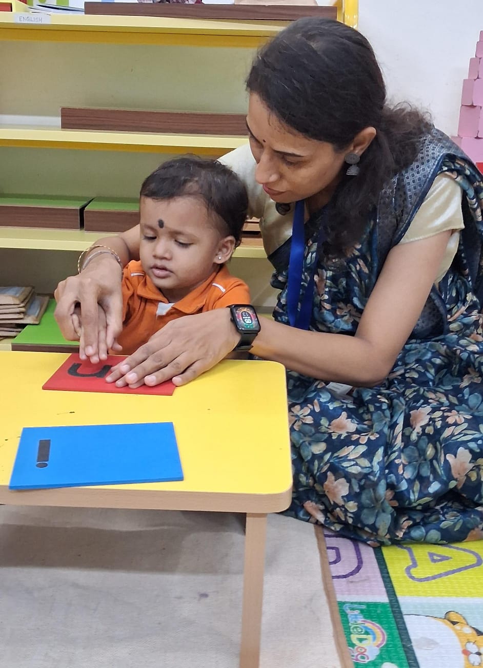 A young child receiving caring individual guidance at Sharada Gurukula